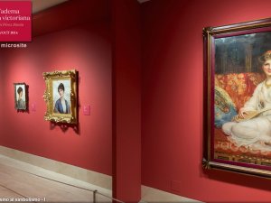 Cuatro obras sobre una pared rojiza de la exposición "Alma Tádema y la pintura victoriana"