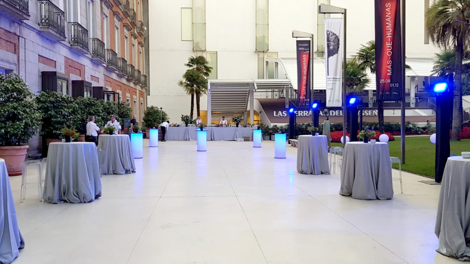 Varias mesas en el jardín preparadas para un evento