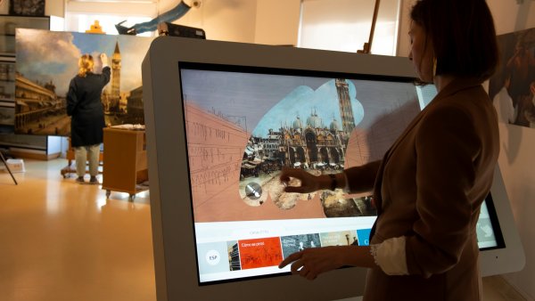 Una chica dibuja en una pantalla interactiva con los resultados del estudio técnico y de la restauración