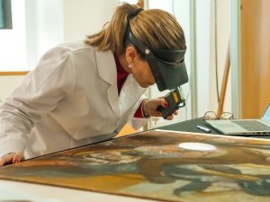 Restorer supervising the paint layer of the work “At the Milliner's” by Degas