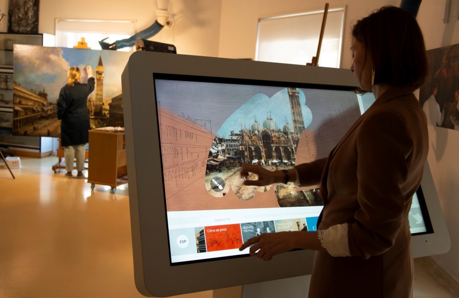 Una chica dibuja en una pantalla interactiva con los resultados del estudio técnico y de la restauración