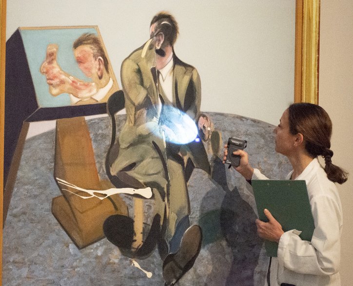 Restorer examining the pictorial surface of the painting in the collection rooms Restorer examining the pictorial surface of the painting in the collection rooms