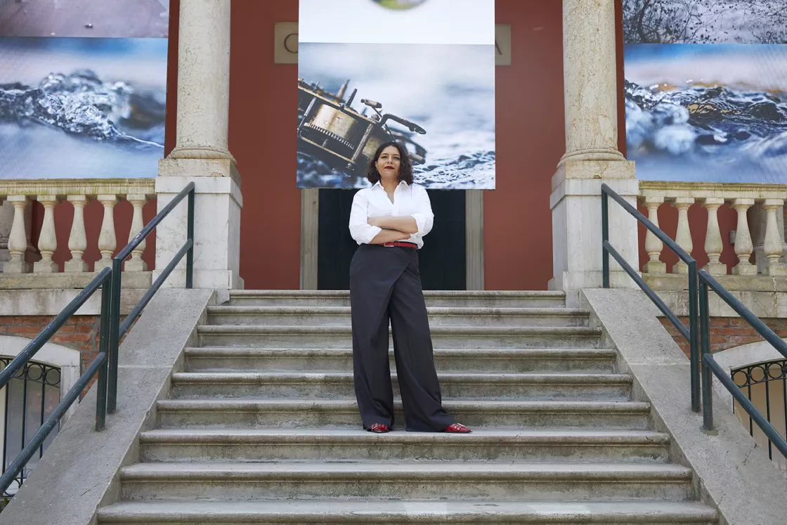 Tarini Malik outside the British Pavilion. "Listening All Night To The Rain", by John Akomfrah, British Pavilion 2024. Image by Jack Hems. Tarini Malik outside the British Pavilion. "Listening All Night To The Rain", by John Akomfrah, British Pavilion 2024. Image by Jack Hems.