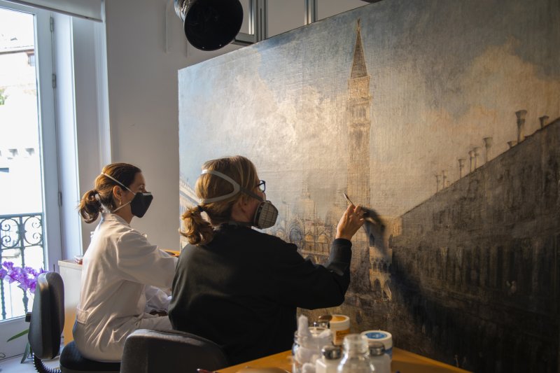 Restauradoras en el proceso de limpieza de la obra “La plaza de San Marco en Venecia” de Canaletto