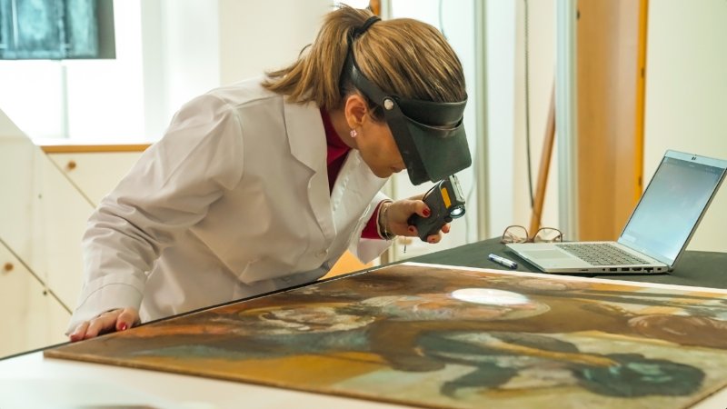 Restorer supervising the paint layer of the work “At the Milliner's” by Degas