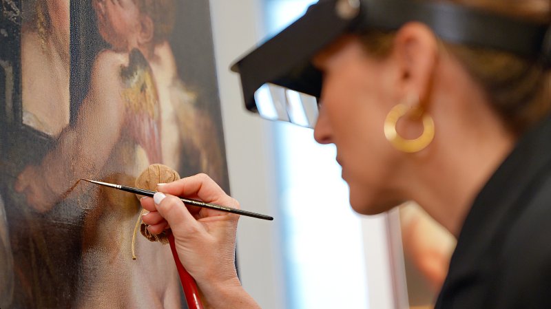 Restauradora durante el proceso de reintegración la obra de Rubens, “Venus y Cupido”