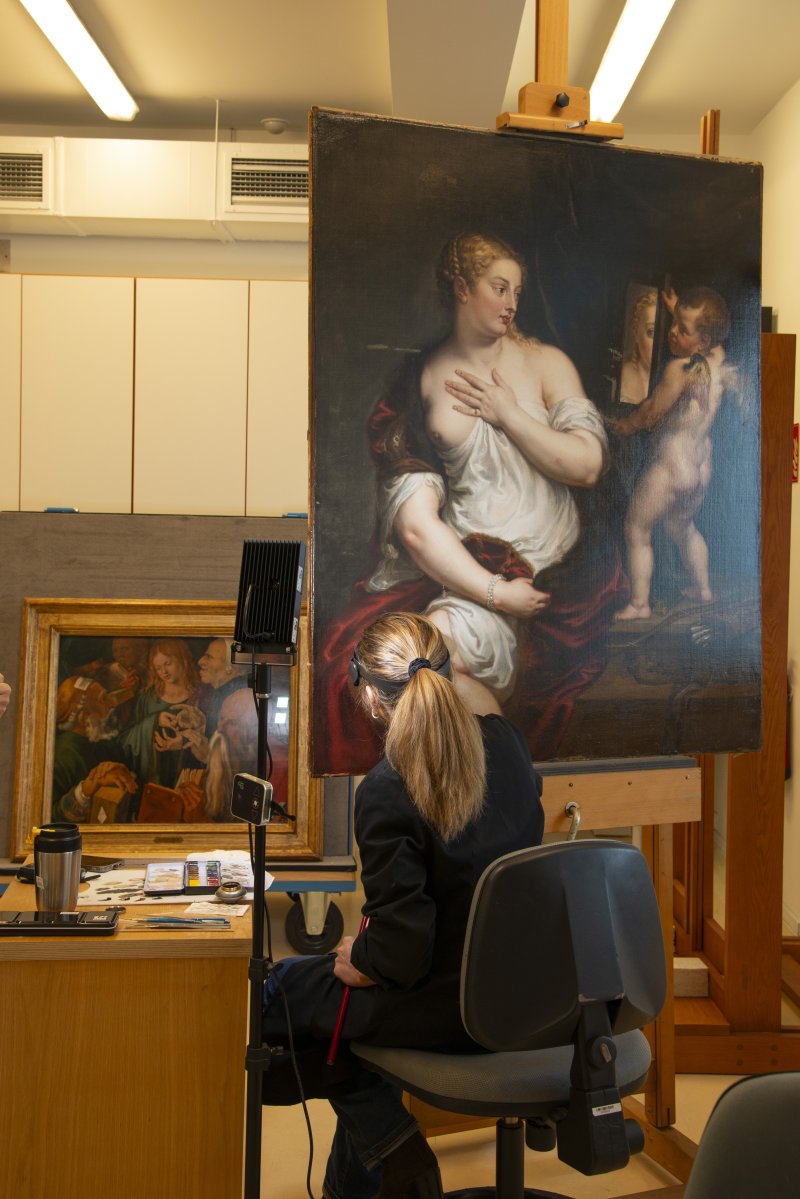 Restauradora durante el proceso de reintegración la obra de Rubens, “Venus y Cupido”