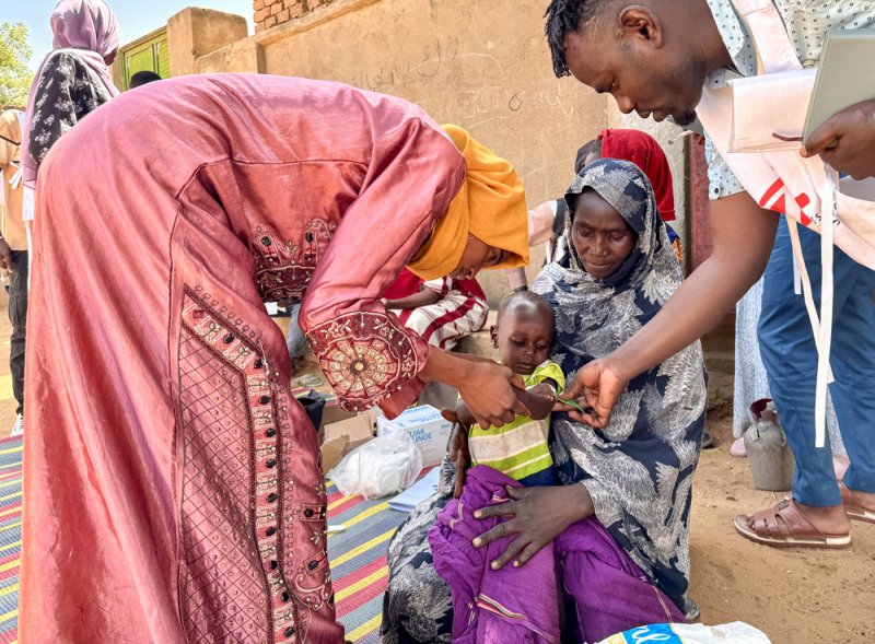 Un voluntario de la comunidad y un miembro del personal de MSF realizan una medición del perímetro del brazo (MUAC, por sus siglas en inglés) a Mohamed Ayoub, de 18 meses, inmediatamente después de que recibiera la vacuna contra el sarampión. Mohamed fue derivado después a un centro de salud especializado para comenzar un tratamiento contra la desnutrición. Un voluntario de la comunidad y un miembro del personal de MSF realizan una medición del perímetro del brazo (MUAC, por sus siglas en inglés) a Mohamed Ayoub, de 18 meses, inmediatamente después de que recibiera la vacuna contra el sarampión. Mohamed fue derivado después a un centro de salud especializado para comenzar un tratamiento contra la desnutrición.