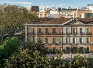 Fachada del Museo Nacional Thyssen-Bornemisza Fachada del Museo Nacional Thyssen-Bornemisza entre árboles, con edificios de Madrid al fondo