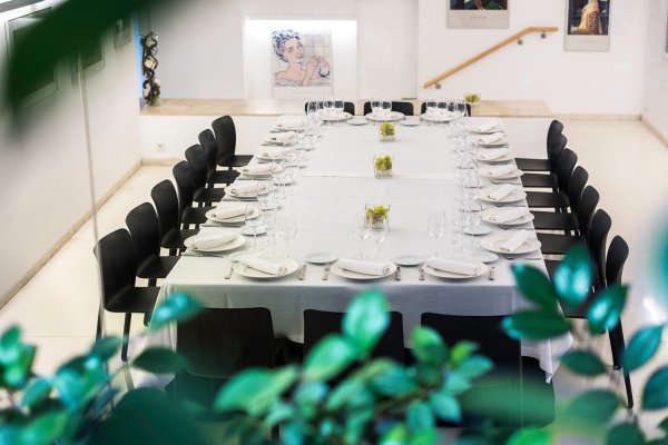Reservado de la cafetería En medio de la sala hay una mesa rectangular muy grande en la que está preparada para una comida con muchos comensales