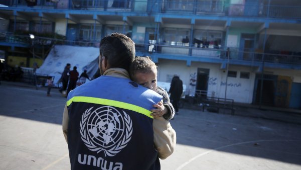 Un trabajador humanitario de UNRWA carga a un niño herido en el patio de una escuela convertida en refugio en el centro de Gaza, uno de los hasta 150 refugios de emergencia gestionados por UNRWA, enero de 2024